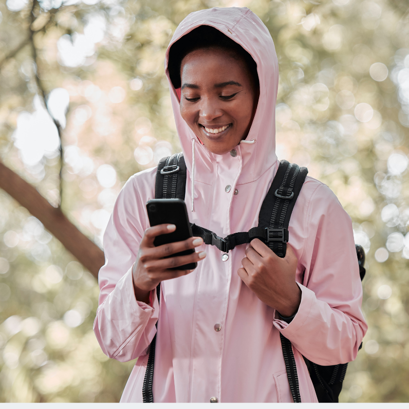 woman smiling while looking at her phone